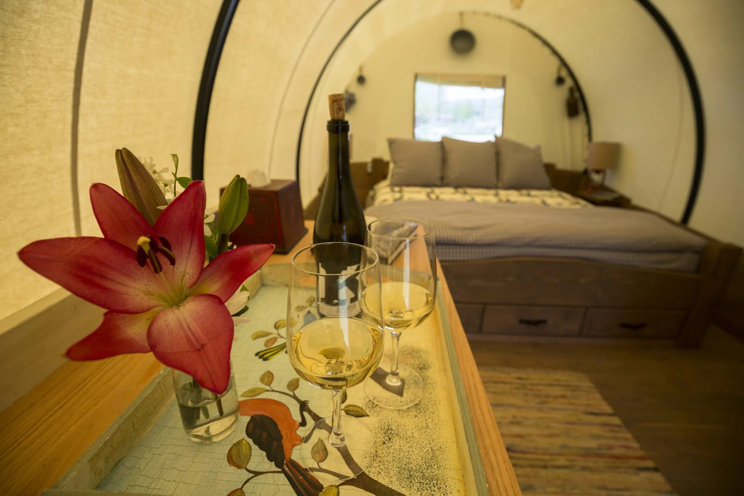 Close-up of two glasses of wine and wine bottle inside a covered wagon room