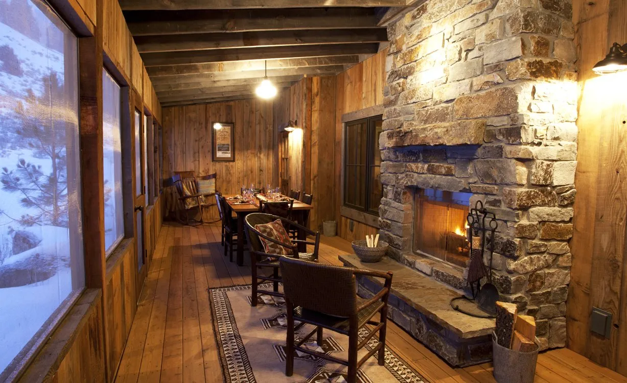 Cabin dining room with a lit fireplace