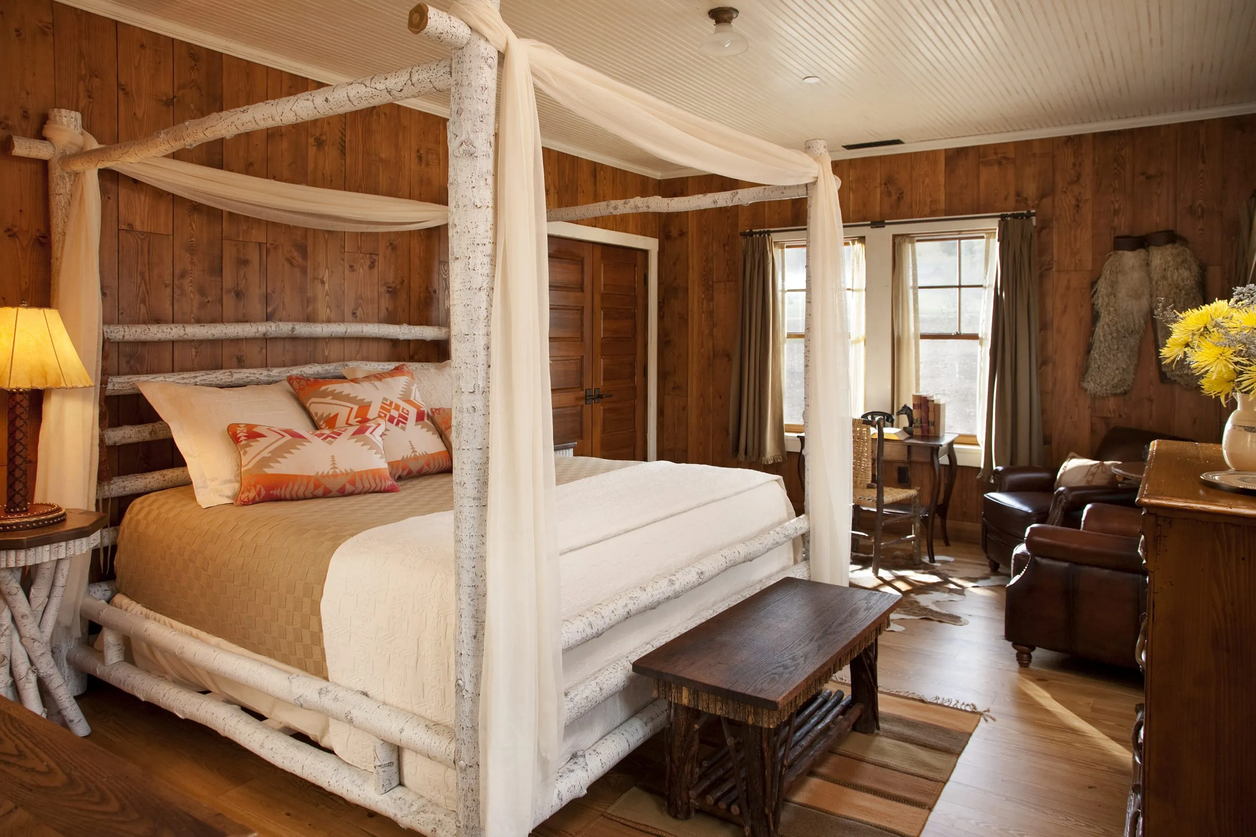Cabin bedroom with white four post bed