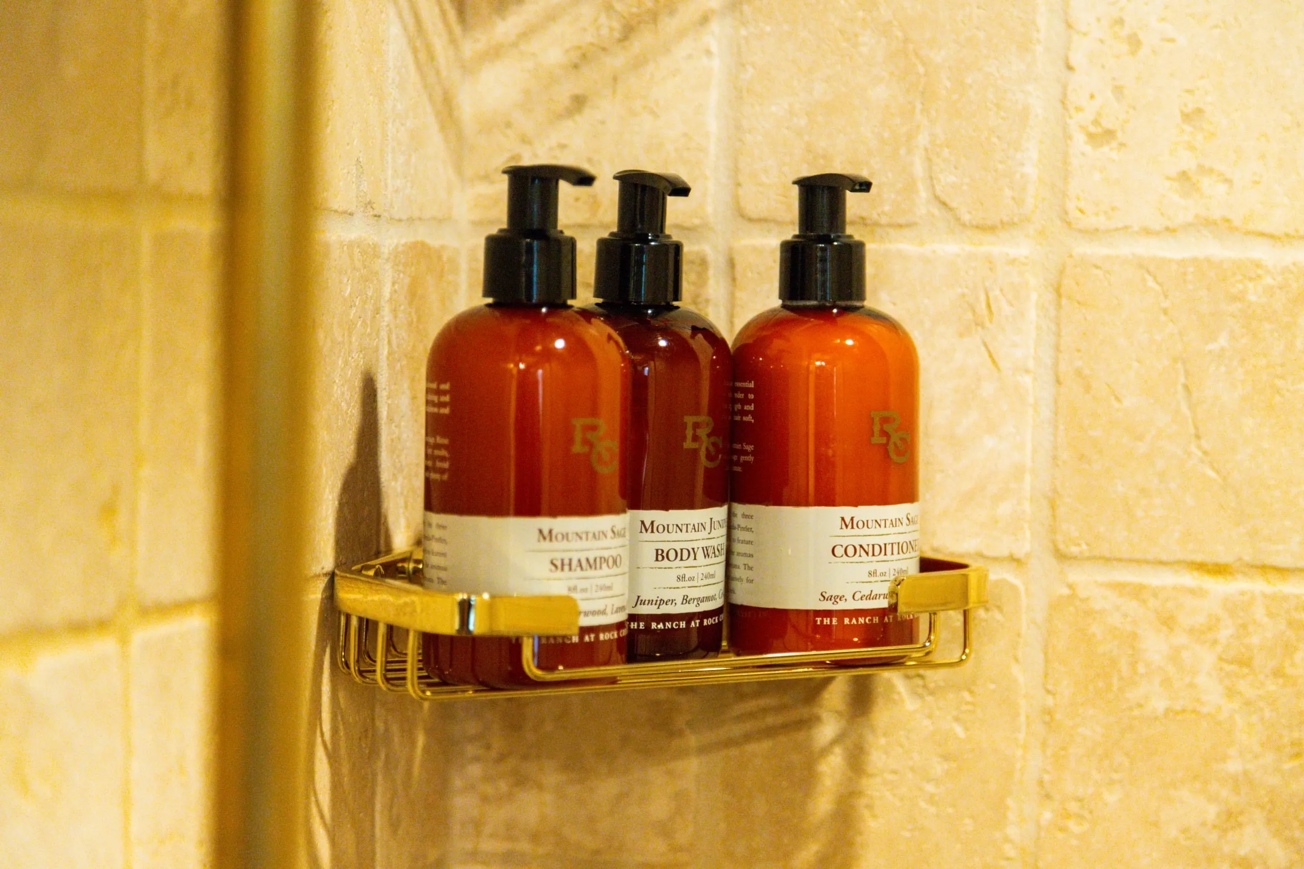 Close-up of shampoo, body wash and conditioner bottles in a shower