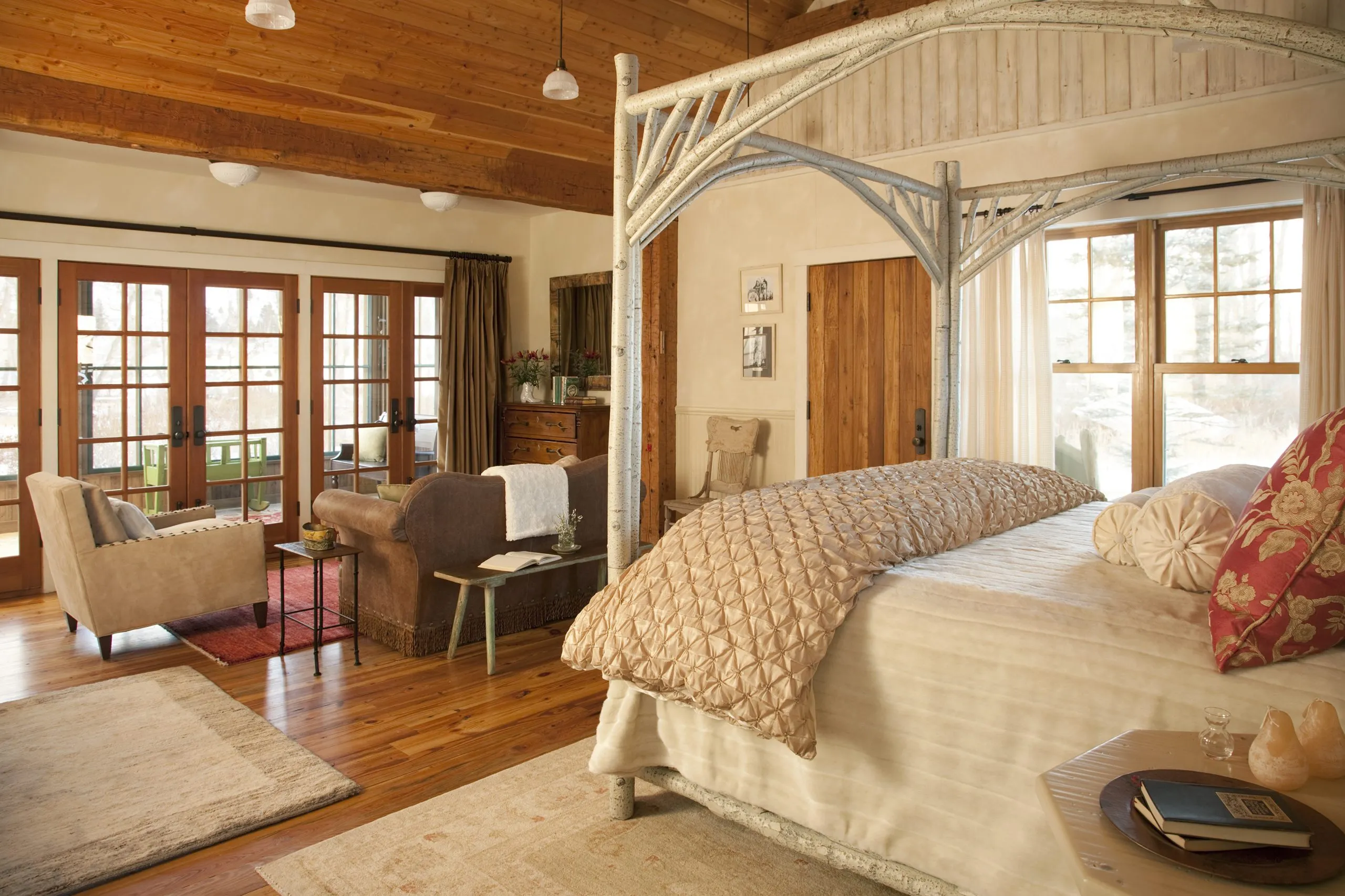 Cabin bedroom with several french doors that lead to a patio