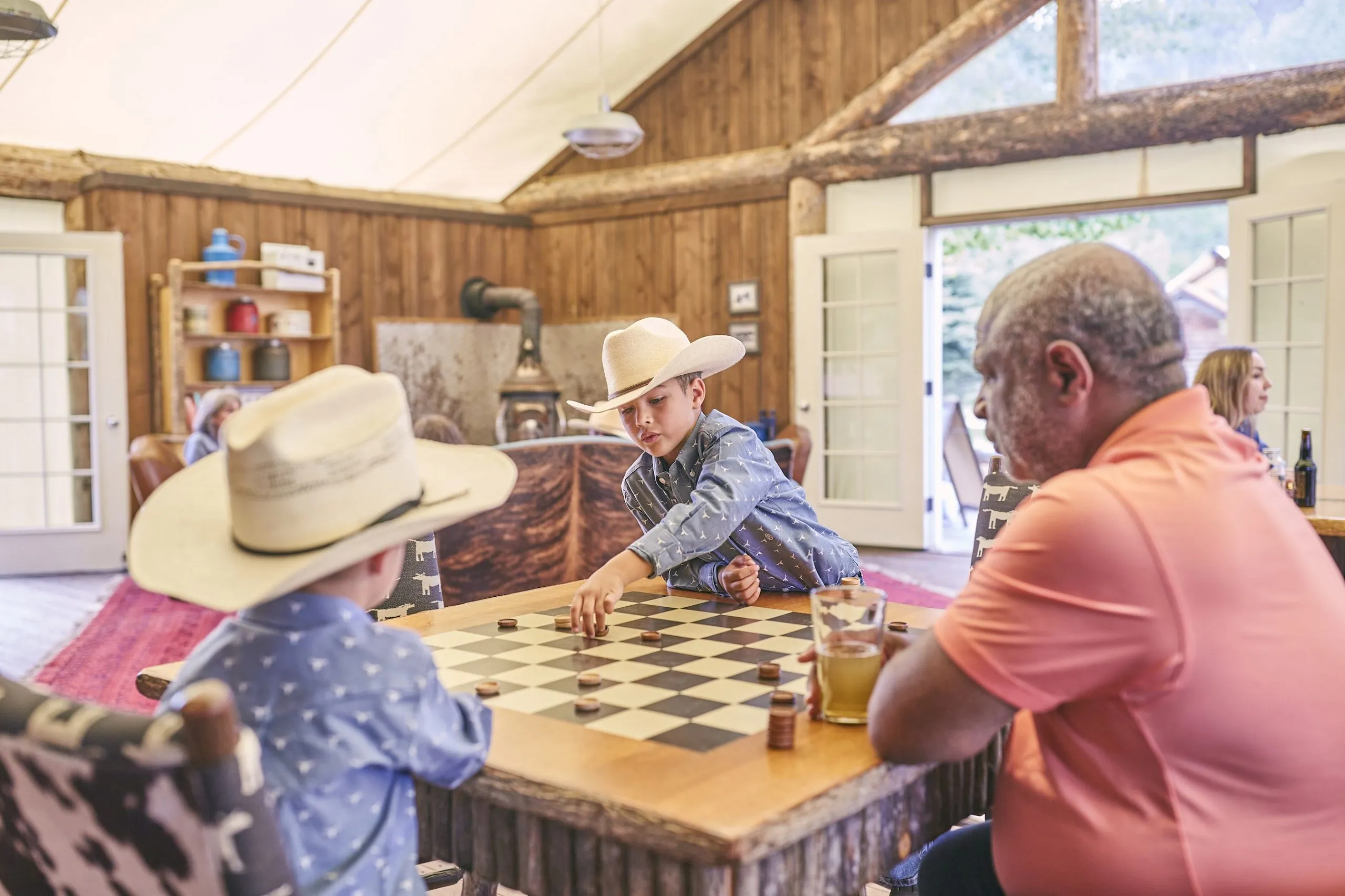 Children play checkers while a man watches