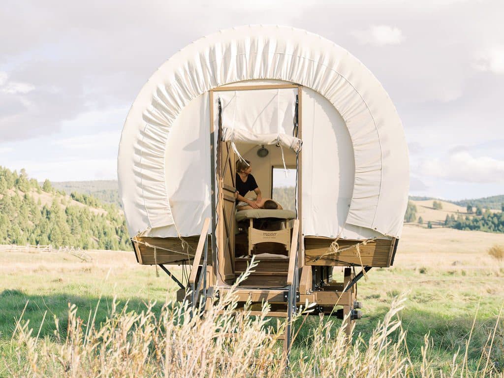 A person getting massaged inside a wagon tent