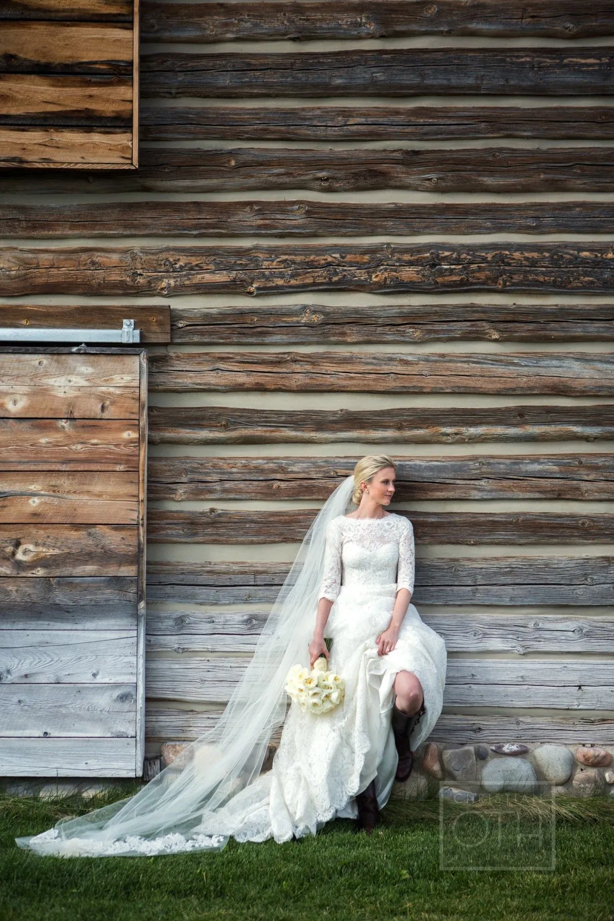 Bride standing against wooden wall