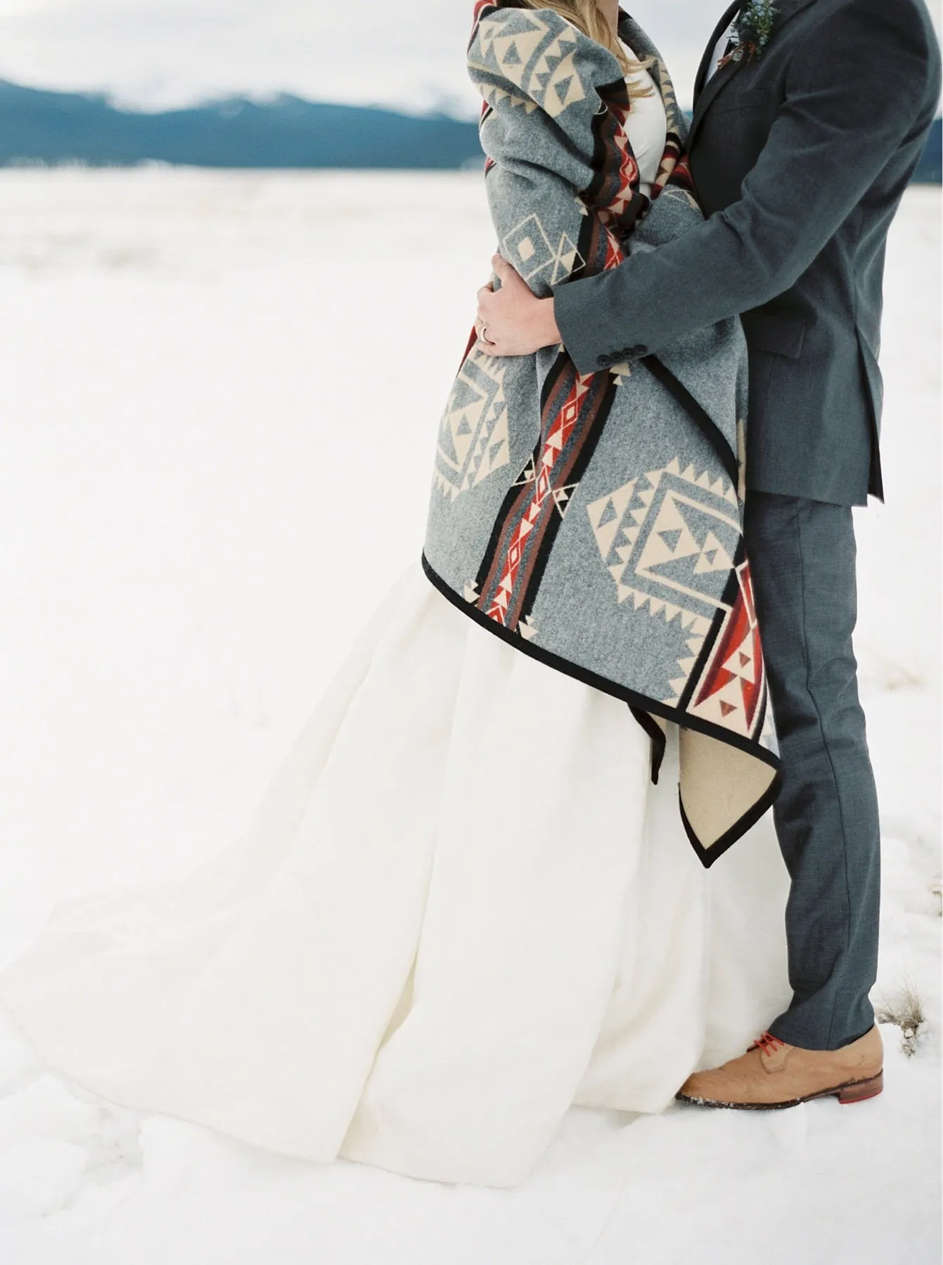 A bride and groom standing in the snow