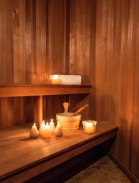 Candles lit on a bench inside a sauna