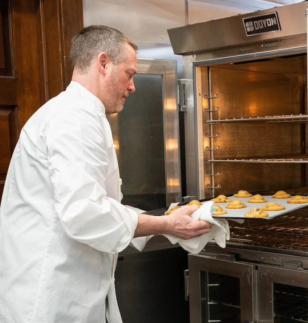 A chef pulls cookies out of an oven