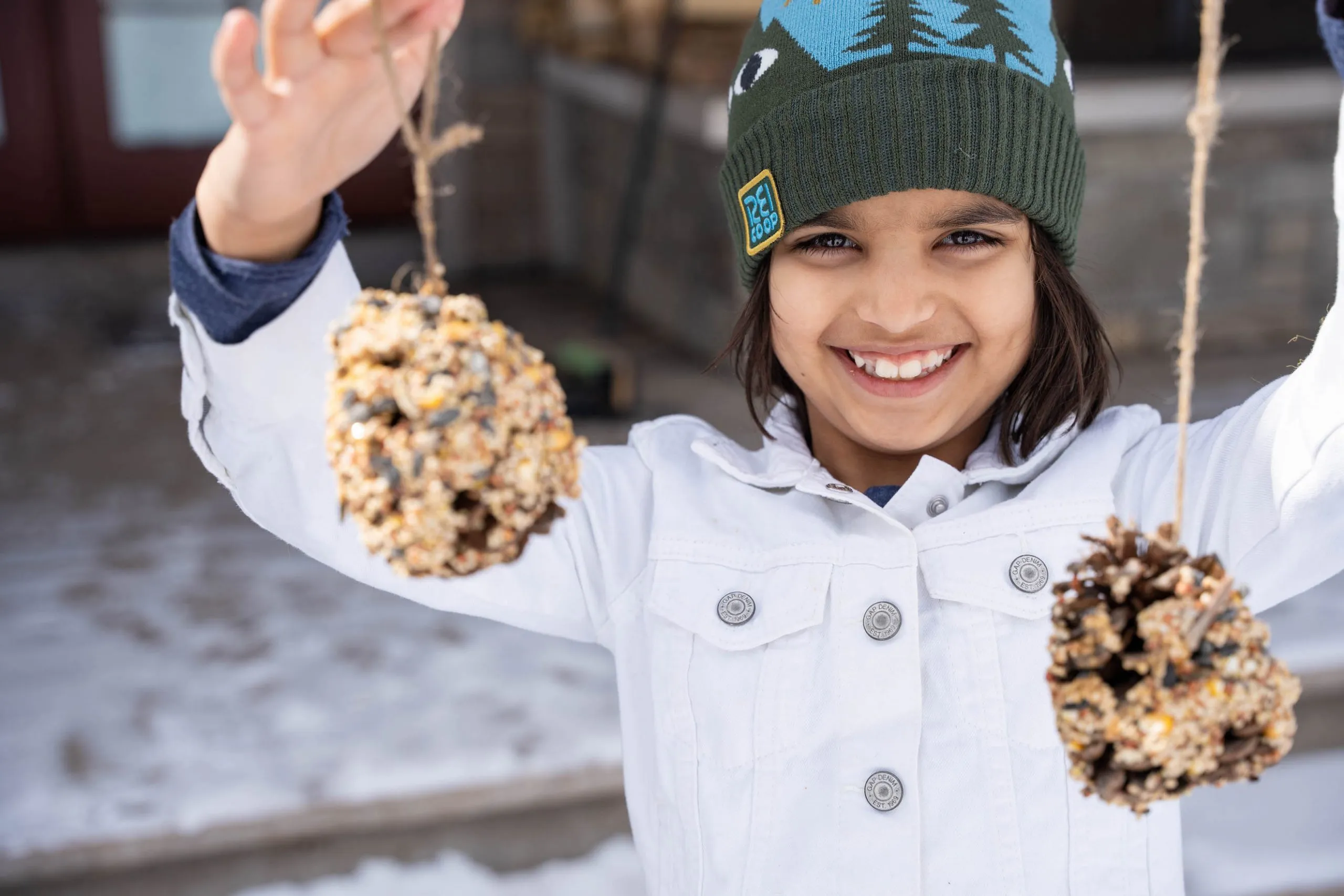 A child holding handmade bird feeders