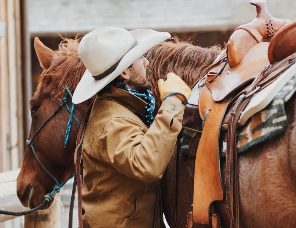 man saddling up his horse man saddling up his horse