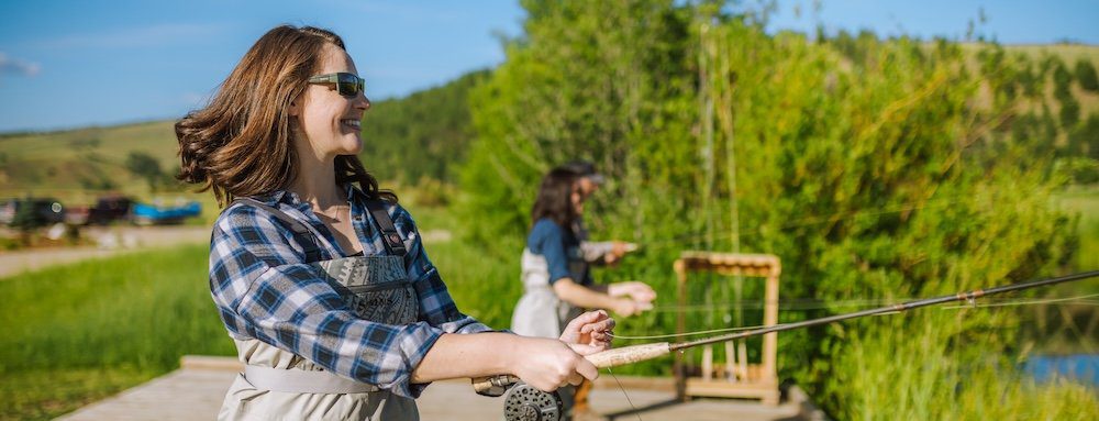 Woman fly fishing with family